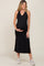 Pregnant woman wearing a black sleeveless v-neck maternity midi dress and white sneakers