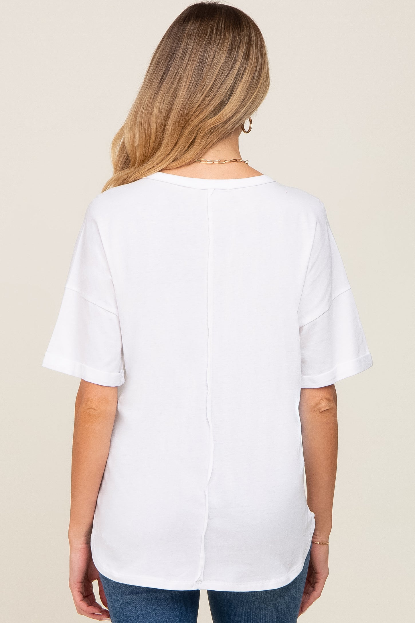 woman wearing a white maternity top with short sleeves and a split back design