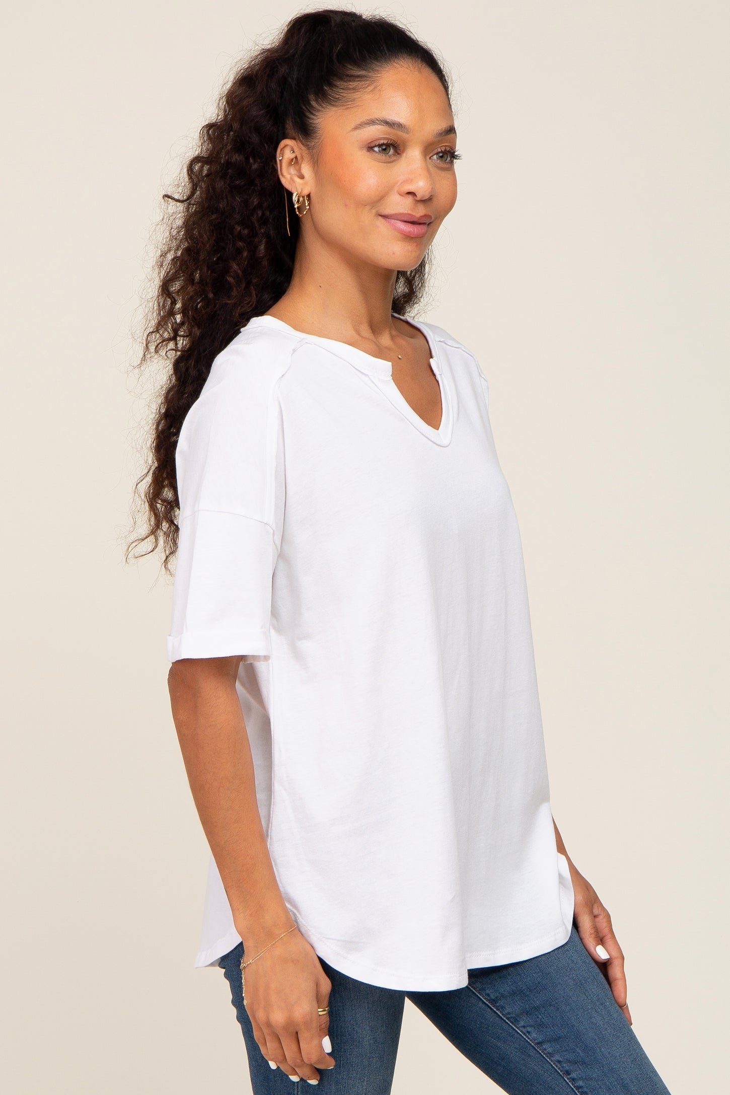 woman wearing an oversized white v-neck t-shirt with short sleeves and a relaxed fit