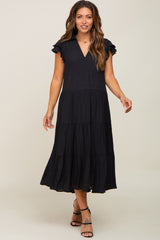 woman wearing a black tiered midi maternity dress with ruffle sleeves and a v-neckline