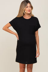 woman wearing a black short sleeve maternity dress with a pocket and a visible baby bump
