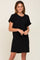 woman wearing a black short-sleeve knit dress with a front pocket and a relaxed fit