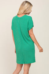 woman wearing a green short sleeve knit dress, showing the back view