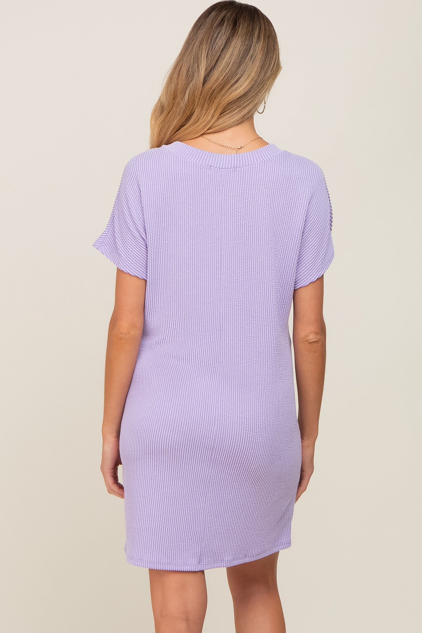 woman wearing a lavender short sleeve maternity dress shown from the back