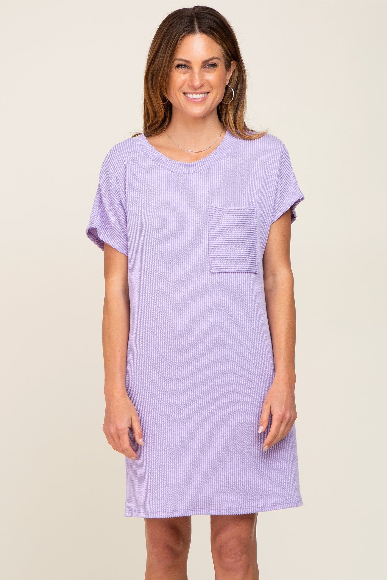 woman wearing a purple short sleeve ribbed dress with a front pocket