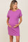 woman wearing a purple ribbed short sleeve maternity dress with a pocket and holding her baby bump