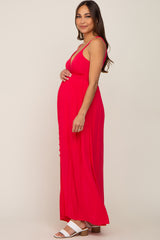 woman wearing a bright red maternity maxi dress with button details and a visible baby bump