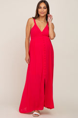 woman wearing a bright pink maternity maxi dress with a v-neckline and button detailing, showing her baby bump