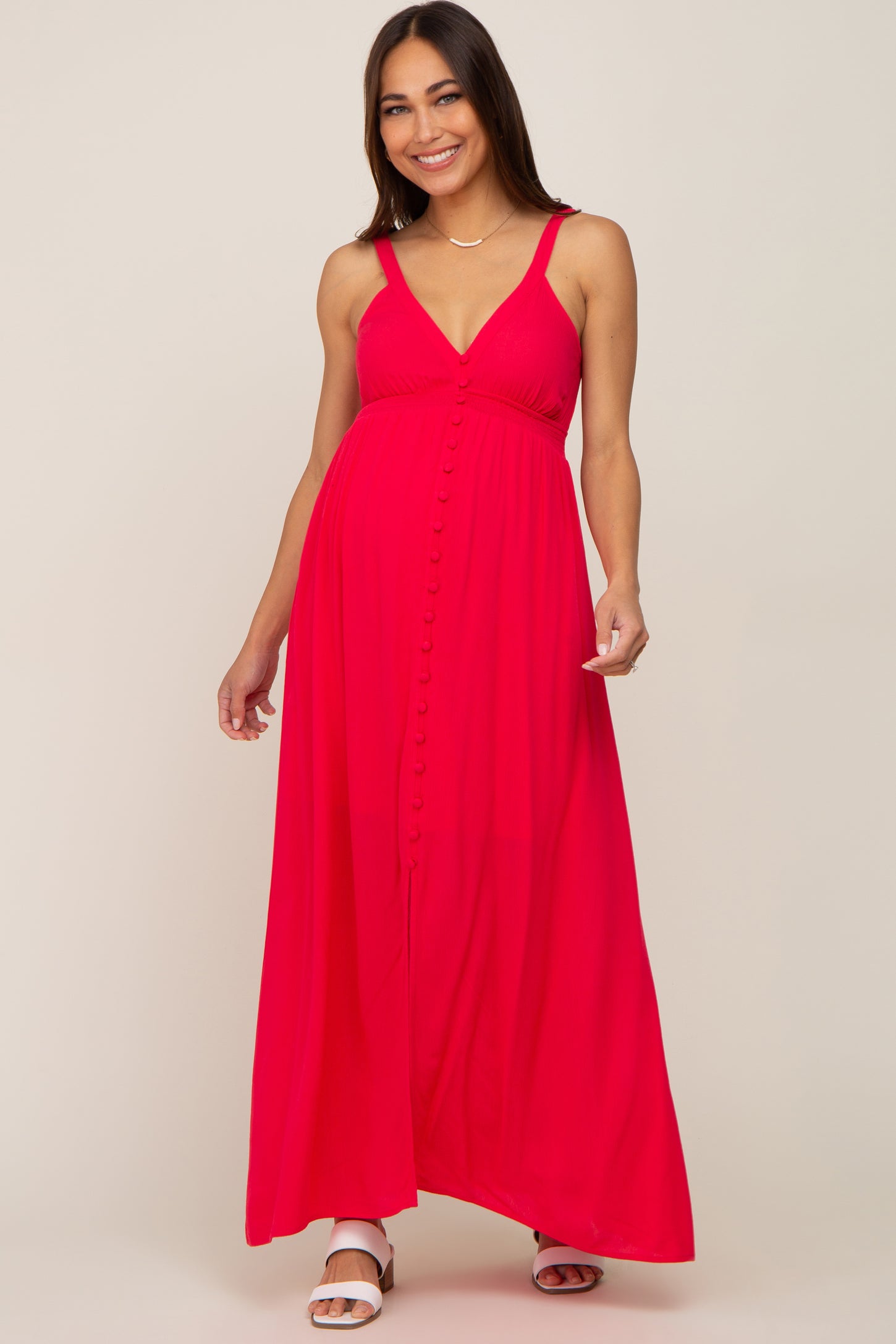 woman wearing a bright pink maternity maxi dress with buttons and a baby bump visible
