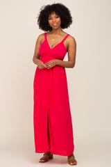 woman wearing a bright pink maxi dress with a button-down front and adjustable straps