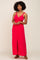 woman wearing a bright pink maxi dress with a button-down front and adjustable straps