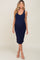 woman wearing a navy blue fitted maternity dress with a scoop neckline and a baby bump visible