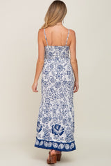 back view of woman wearing white and blue floral print maxi dress with spaghetti straps
