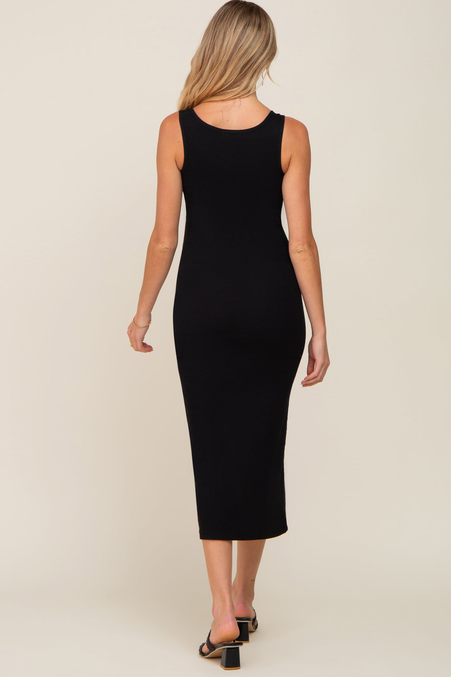 woman wearing a black ribbed maternity midi dress, showing the back view