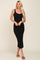 woman wearing a black ribbed tank dress with a knee-length hem and brown sandals