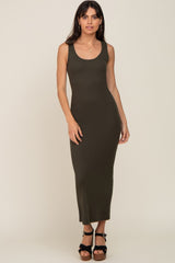 woman wearing a dark olive green sleeveless ribbed maxi dress with a fitted silhouette and high slit, standing confidently