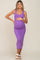 woman wearing a purple ribbed maternity dress, showing off her baby bump with a hand on her belly