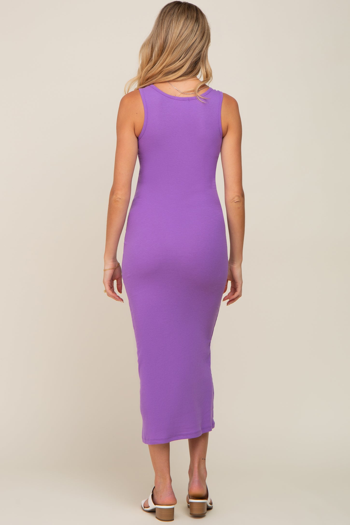 woman wearing a purple ribbed maternity dress with a form-fitting silhouette and a mid-calf length