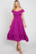 woman wearing a purple off-the-shoulder midi dress with a smocked bodice and ruffled hem