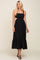 woman wearing a black sleeveless midi dress with side cutouts and a tiered hem