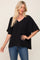 blonde woman wearing a black v-neck oversized pocket tee and blue jeans