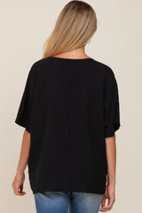 woman wearing a loose-fitting black maternity top, shown from the back, with short sleeves and a curved hemline