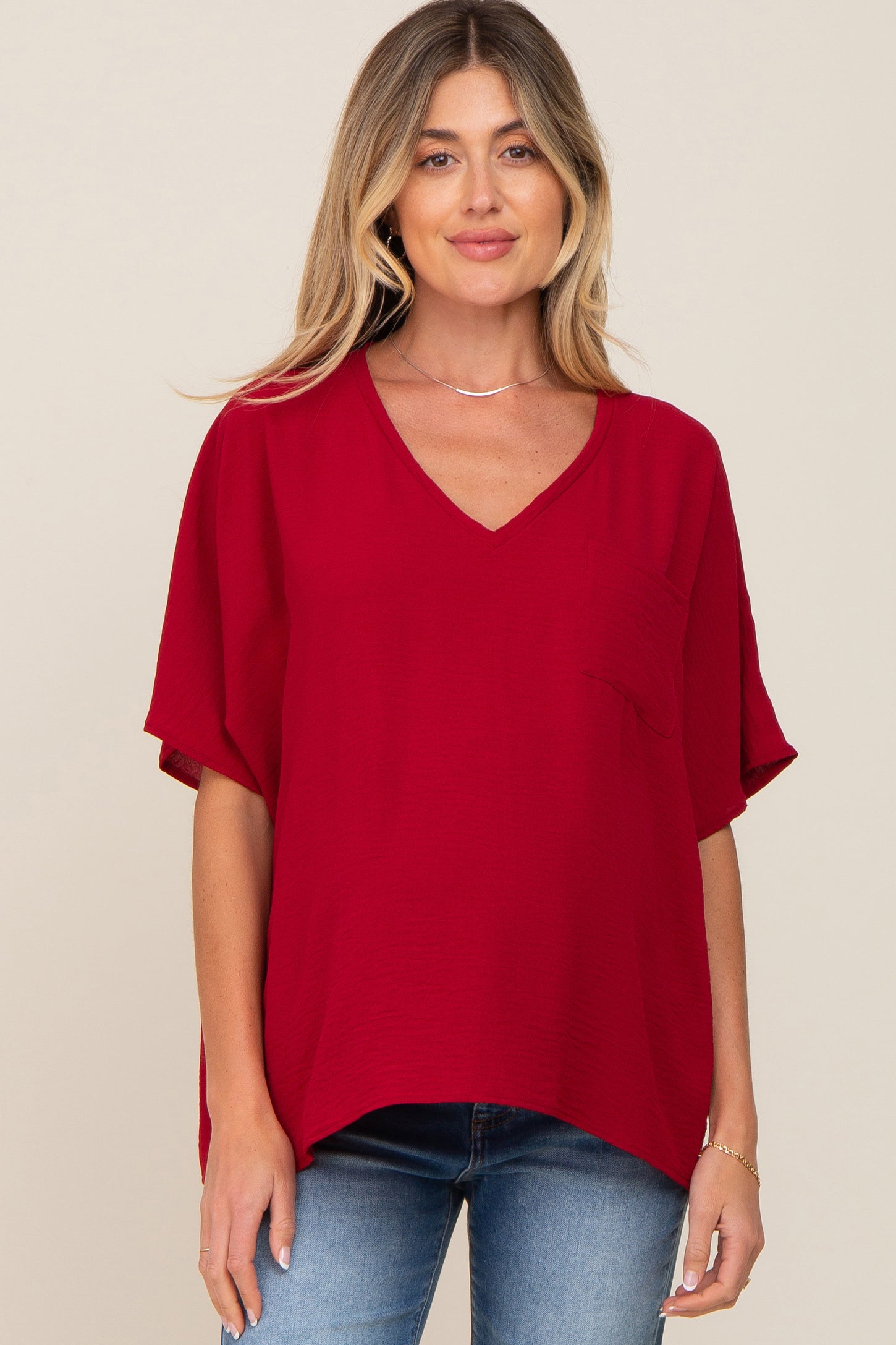 woman wearing a red v-neck maternity top with a pocket and short sleeves