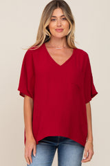woman wearing a red v-neck maternity top with a pocket and short sleeves
