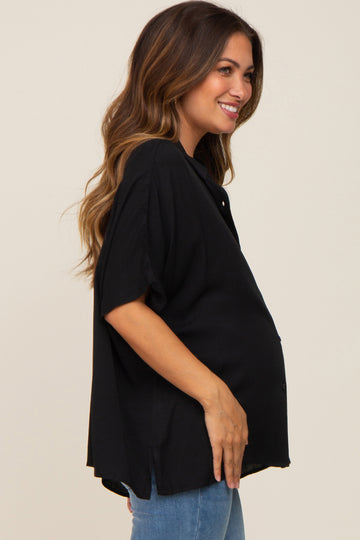 woman wearing a black short sleeve maternity top and holding her baby bump