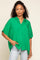 woman wearing a bright green oversized button-up shirt with short sleeves and a relaxed fit