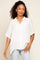 woman wearing a loose-fitting white button-up shirt with rolled sleeves and light blue jeans
