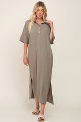 Woman wearing a sage green short sleeve maxi shirt dress with side slits and button collar