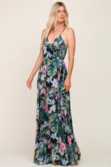 woman wearing a tropical floral maxi dress with adjustable spaghetti straps and a tie waist