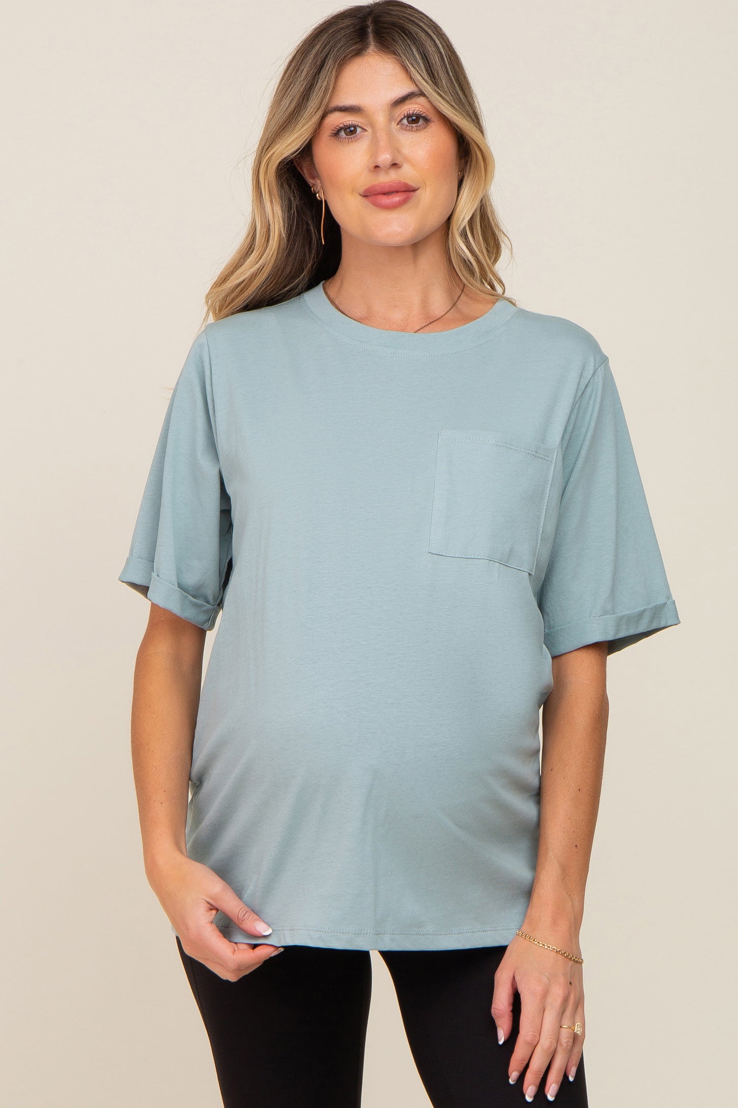 woman wearing a light blue maternity t-shirt with a pocket and rolled sleeves, showing her baby bump
