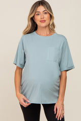 woman wearing a light blue maternity t-shirt with a pocket and rolled sleeves, showing her baby bump
