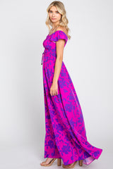 woman wearing a vibrant pink and purple floral off-the-shoulder maxi dress with a smocked bodice and flowy skirt