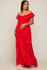 woman wearing a red floral off-the-shoulder maternity maxi dress and holding her baby bump