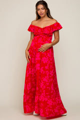 woman wearing a pink floral off-the-shoulder maternity maxi dress and holding her baby bump