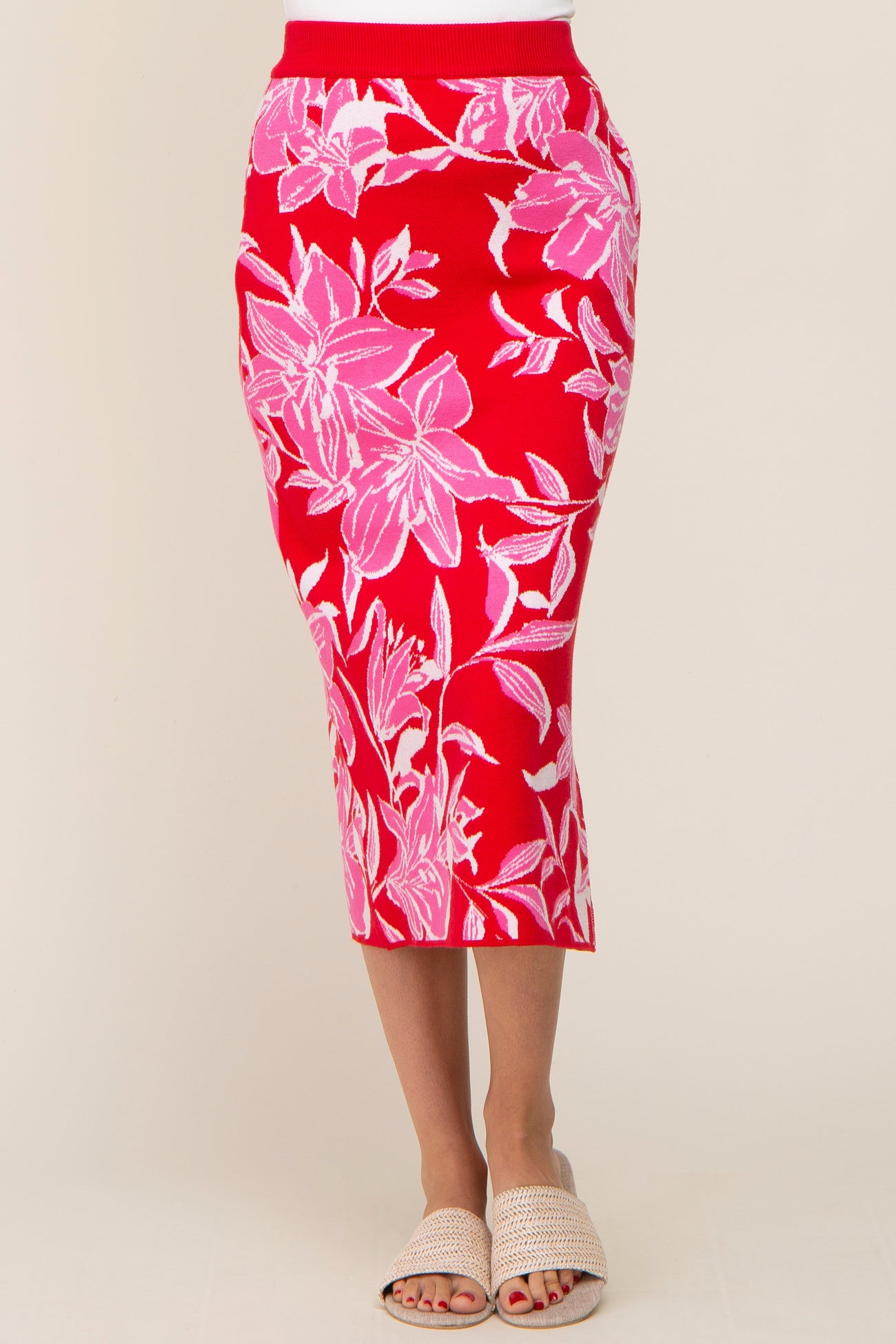 woman wearing a red floral-printed midi skirt with a ribbed waistband and a fitted silhouette