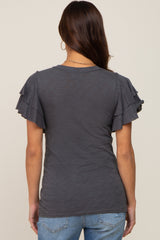 Back view of a woman wearing a charcoal grey t-shirt with tiered ruffle sleeves and blue jeans