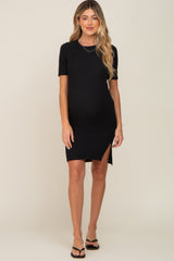 woman wearing a black short sleeve maternity dress with a side slit and showing her baby bump