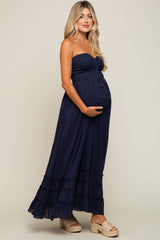 pregnant woman in navy blue strapless smocked maternity maxi dress with tiered skirt and platform sandals