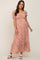 woman wearing an orange floral maternity maxi dress with puff sleeves and a gathered front, showcasing a baby bump