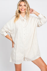 woman wearing a beige linen button-up romper with long sleeves and a collared neckline