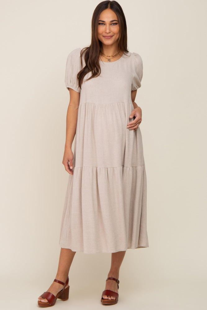 woman wearing a beige short sleeve tiered maternity midi dress with brown platform sandals