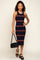 woman wearing a navy and brown striped midi dress holding a black leather handbag and wearing platform sandals