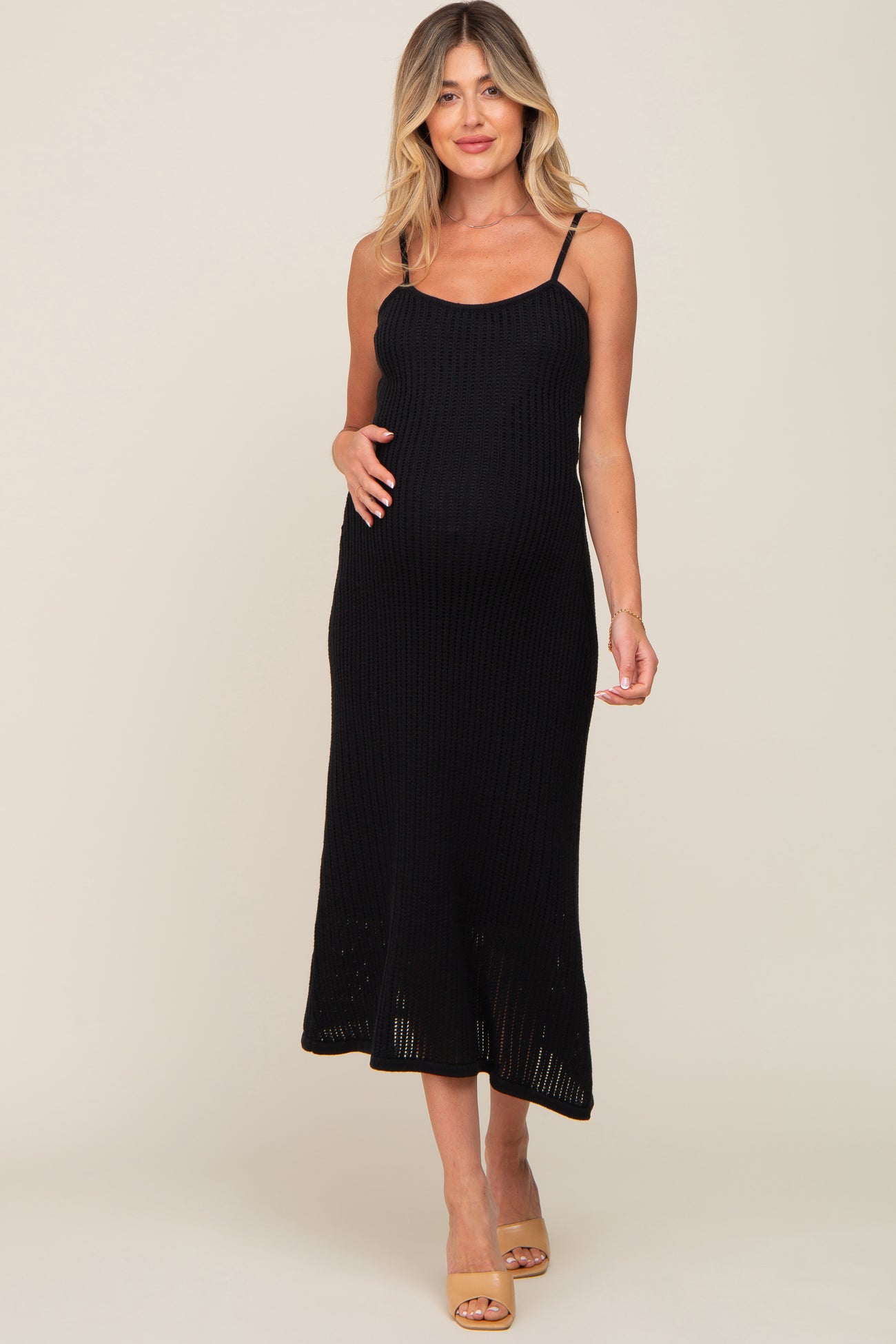 pregnant woman wearing a black ribbed knit maternity midi dress with spaghetti straps and tan heels
