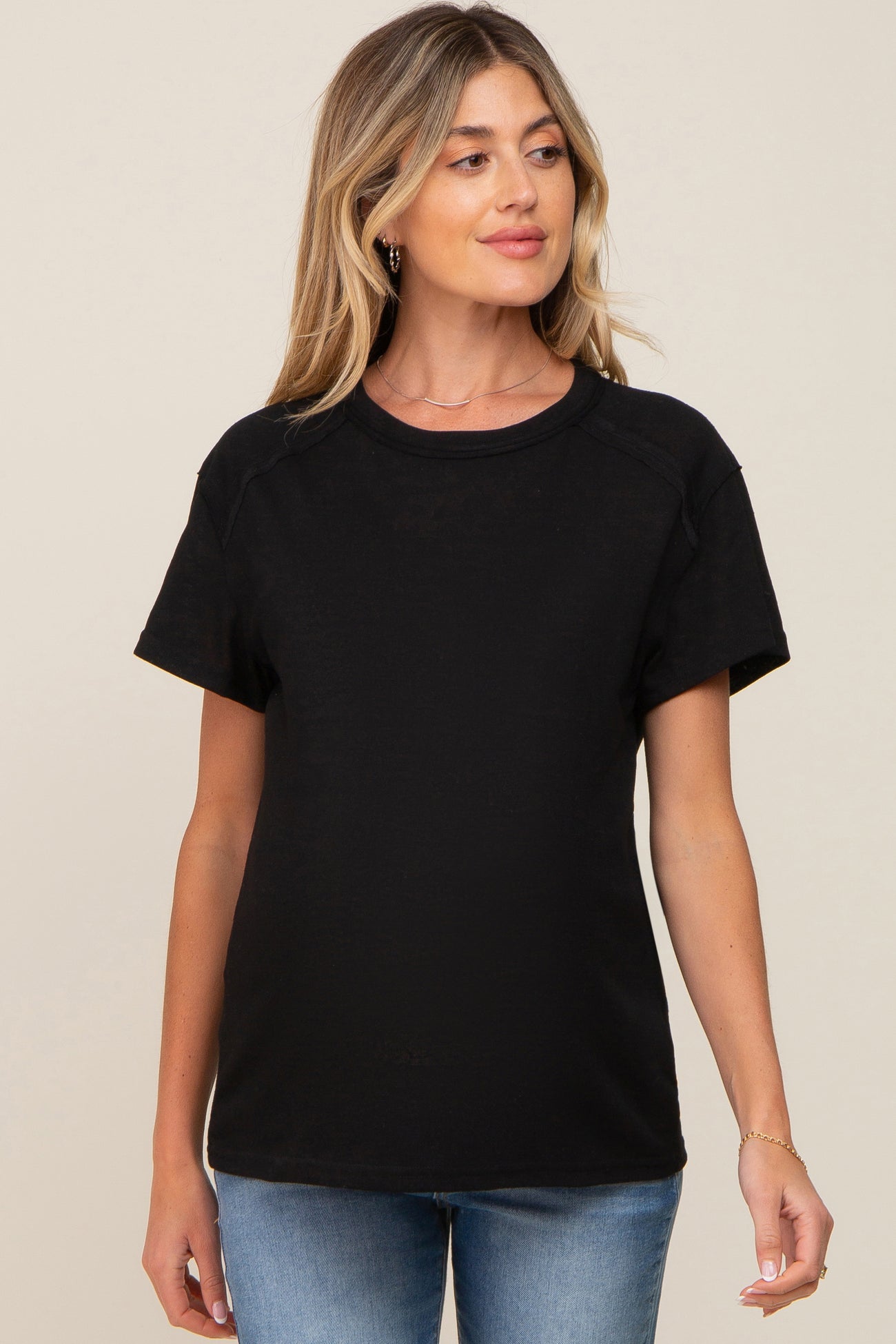 woman wearing a black maternity t-shirt with short sleeves and a relaxed fit, showing her baby bump