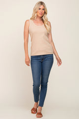 woman wearing a beige ribbed tank top paired with fitted blue jeans and tan slide sandals
