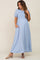Pregnant woman wearing a light blue smocked maternity maxi dress with puff sleeves and pockets